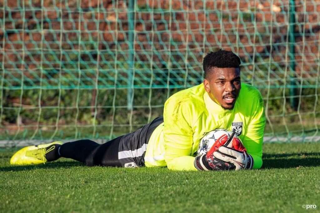 Jamal Blackman is lying in the and holding the football or posing for taking the picture