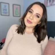 Ruby May is wearing off white shirt and smiling while posing for the picture
