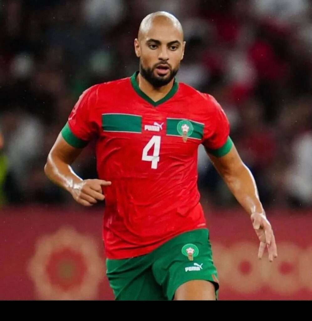 Sofyan Amrabat is wearing red t shirt and shorts or running in the ground or taking the picture