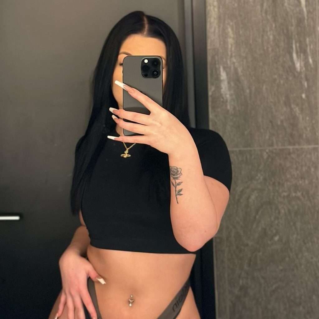 Rosa Jasminn is taking her mirror selfie while wearing a cropped shirt.
