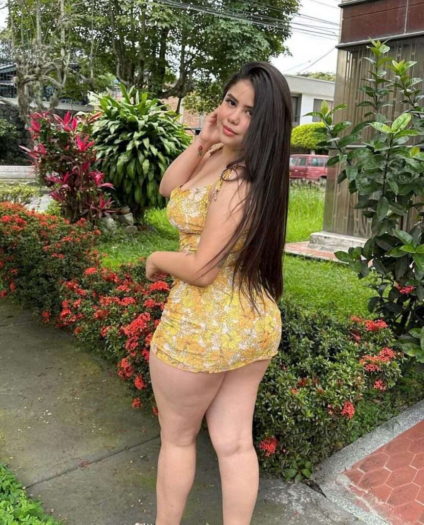 Valentina Salazar is wearing yellow dress and smiling while posing for the picture