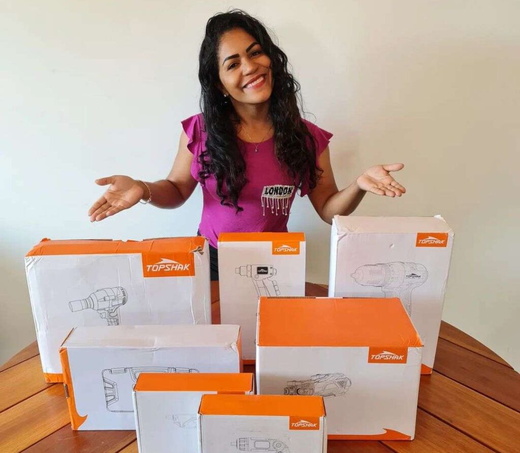 Daiani Oficial in the pruple t-shirt pair with black pants while taking picture with boxes