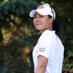 Danielle Kang in the white full stunning outfit pair with white cap while smiling towards camera