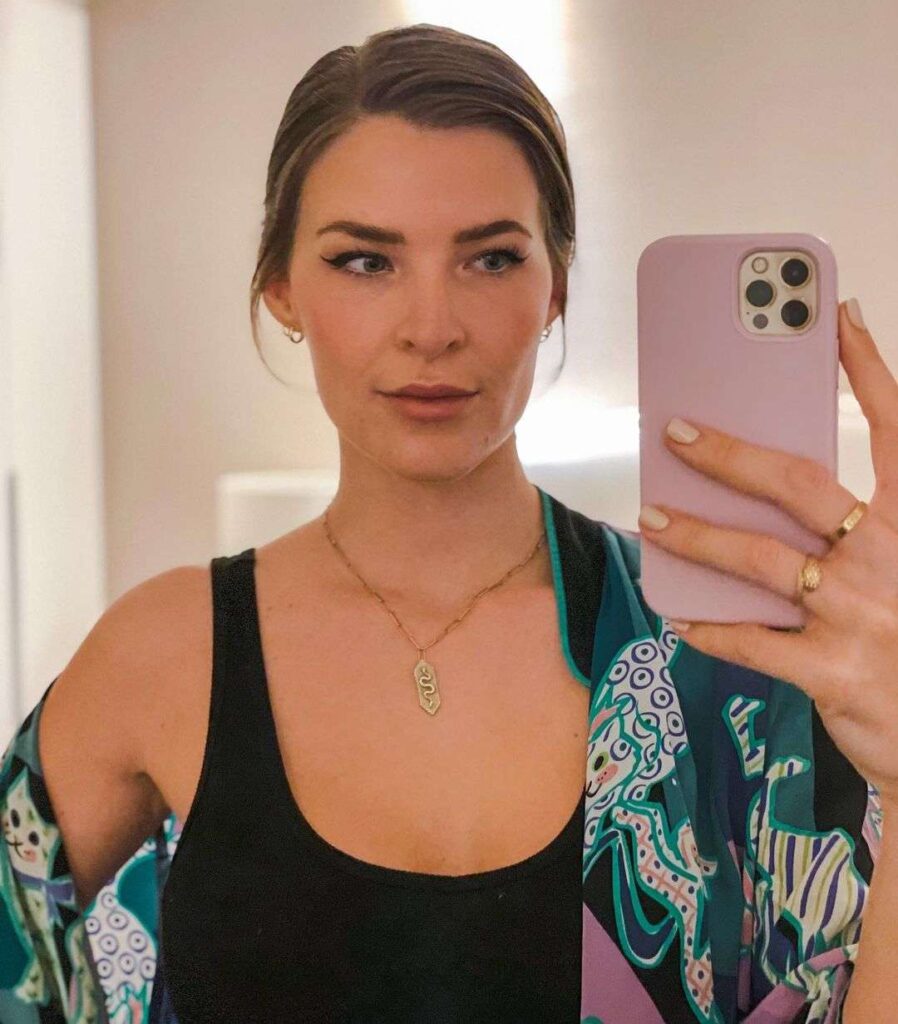 Kitty Plays in the black tank top pair with printed green scarf and elegant jewellery while taking a selfie in the front of mirror