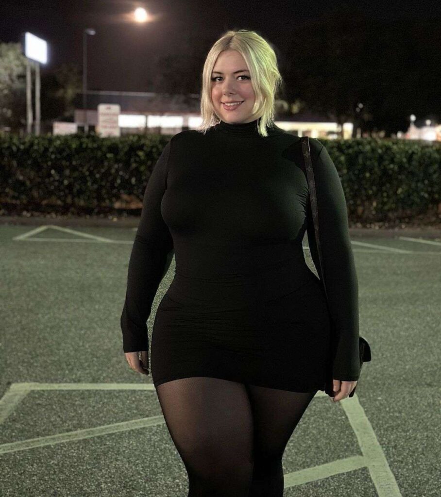 Mystic in the black full sleeves top pair with black pantyhose while smiling towards camera