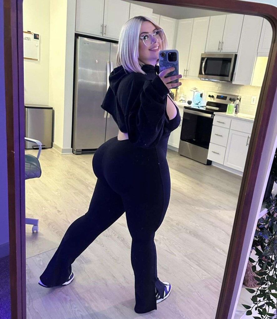 Mystic in the black crop hoodie pair with pants while taking picture in the front of mirror