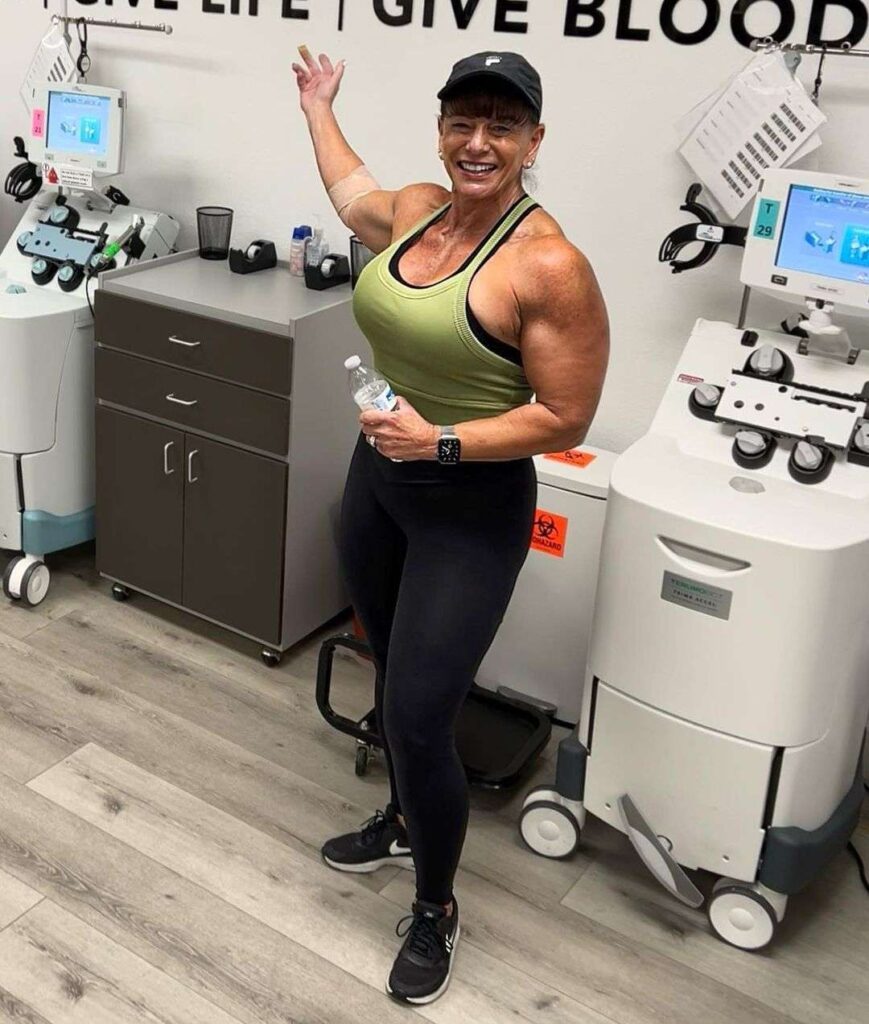 tk_fit in the green tank top pair with black leggings, black cap and am joggers while smiling towards camera