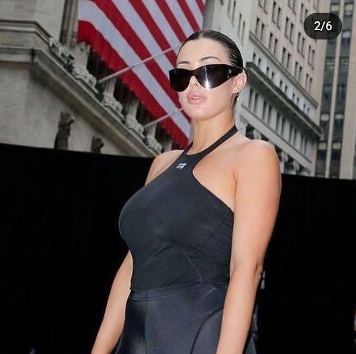 Bianca Censori is wearing black dress and glasses or posing while taking the picture