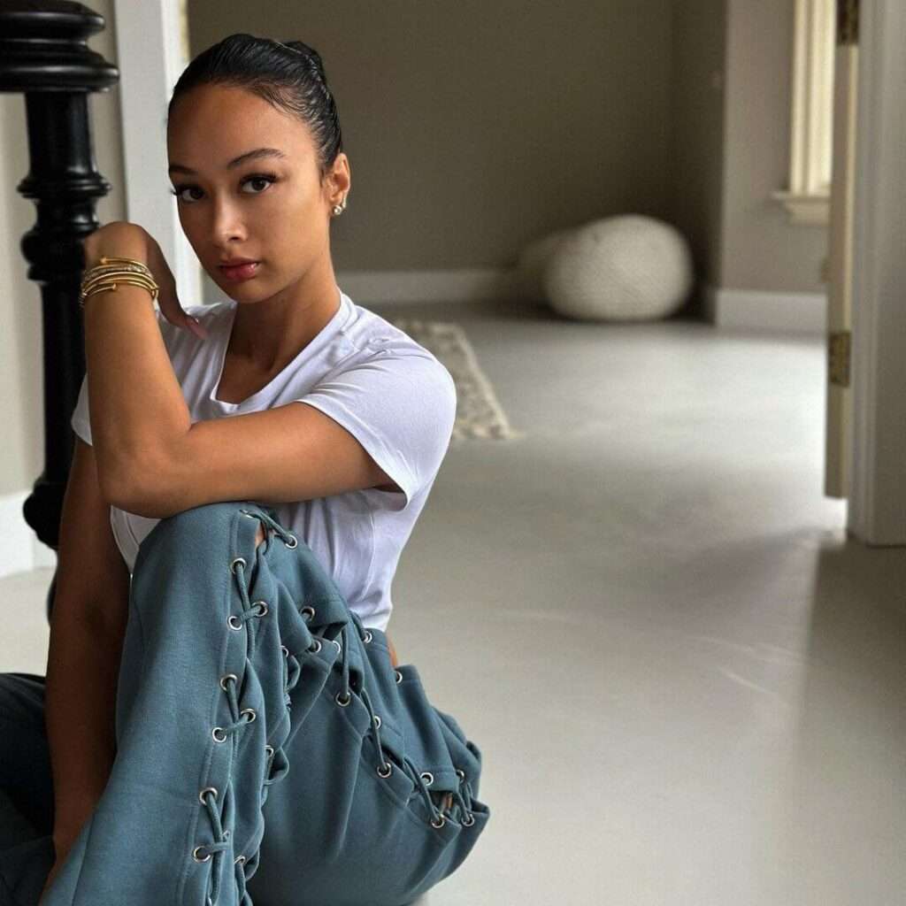 Draya Michele is wearing white t shirt over blue trouser and sitting while posing for the picture