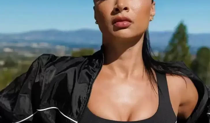 Draya Michele is wearing black bra over coat and taking sun kissed while posing for the picture