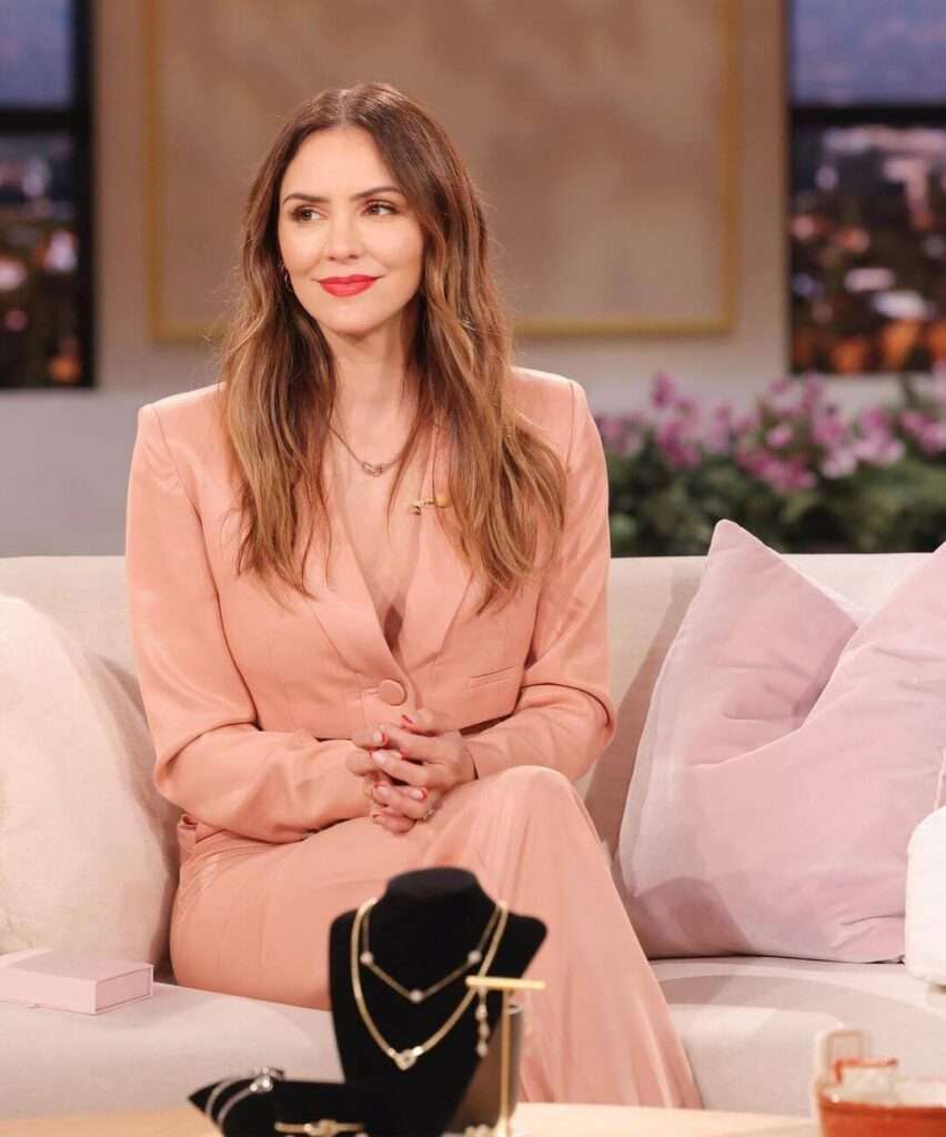 Katharine Mcphee is wearing pink dress and neckless or smiling while posing for the picture
