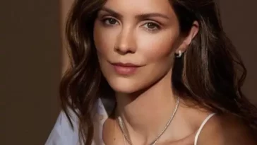 Katharine Mcphee is wearing white bra over white shirt and neckless or smiling while posing for the picture