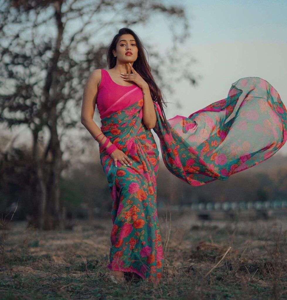 Gima Ashi in the pink blouse and printed saree while looking towards camera and poses for a photo
