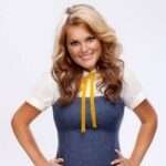 Brittany Ashton Holmes is wearing white and blue dress or smiling while posing for the picture