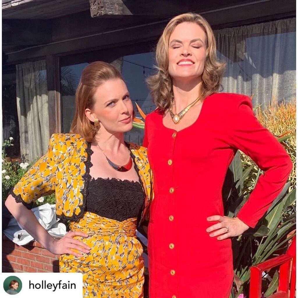 Missi Pyle is wearing red dress and standing with her friend or smiling while posing for the picture