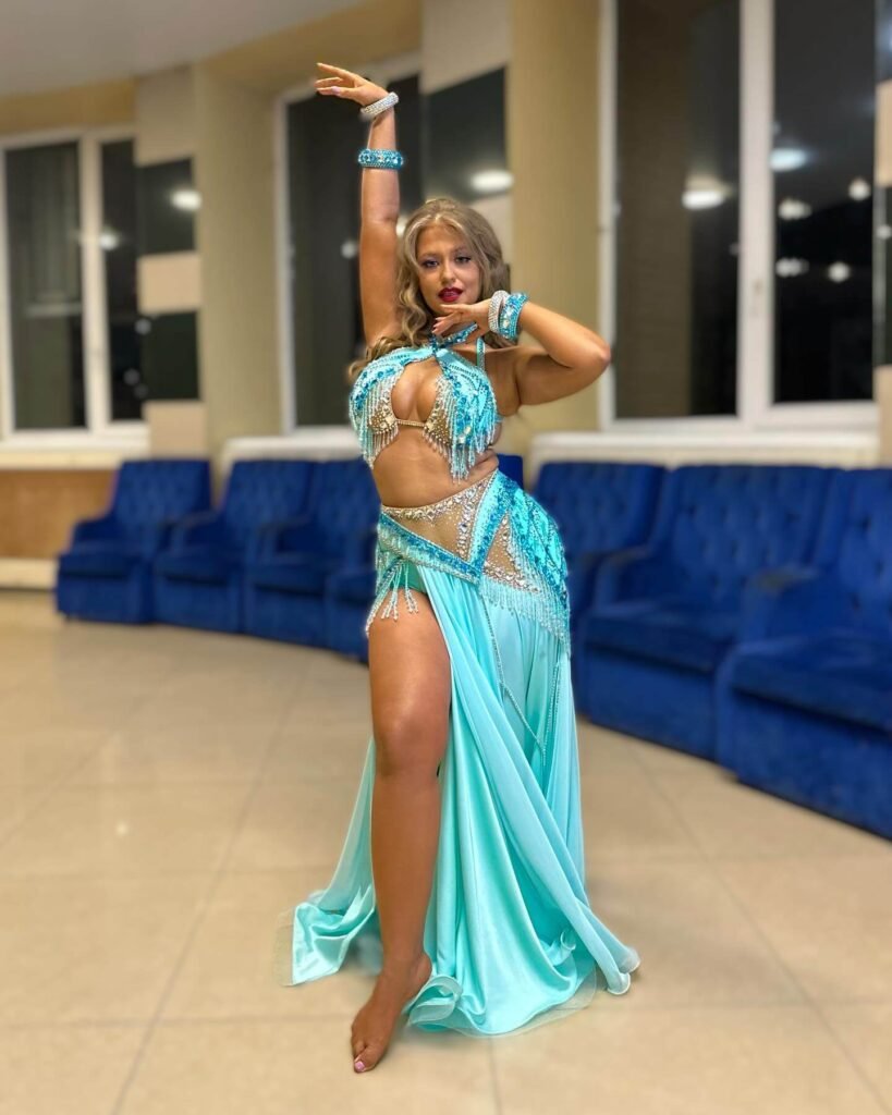 Viktorya Cherkashina: Age, Height, Weight, BIO, Family, Net Worth - Complete Guide 13 Viktorya Cherkashina strikes a confident dance pose in a turquoise-blue belly dance outfit with crystals and fringe detailing.
