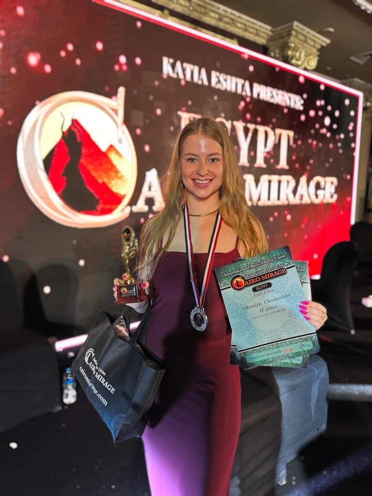 Viktorya Cherkashina: Age, Height, Weight, BIO, Family, Net Worth - Complete Guide 14 Viktorya Cherkashina smiling and holding her trophy and diploma after placing at the Cairo Mirage Egypt Cup Superstar competition.