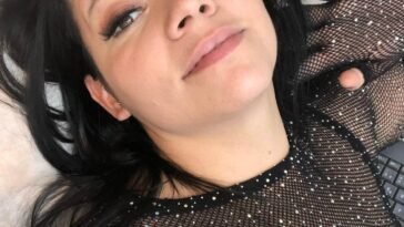 Close-up of Colombian model Yurley Rúa lying down in a black fishnet rhinestone top, soft makeup, and natural expression.