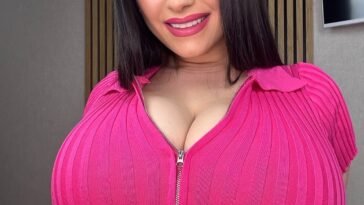 Rozzzywow in a fitted pink ribbed zip-up crop top, smiling with straight black hair and glam makeup